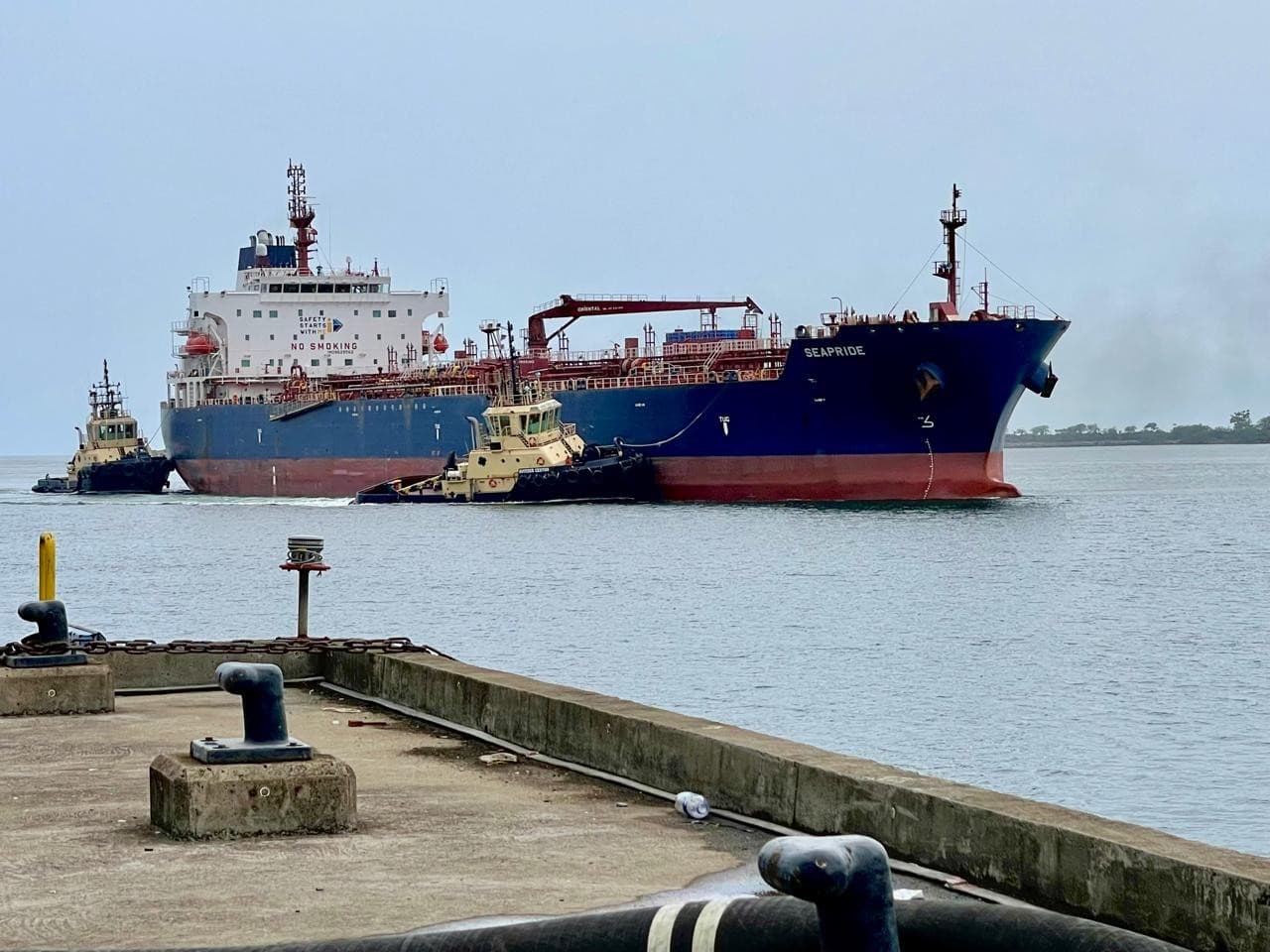 Tanker SEAPRIDE maneuvering into port with tug assistance