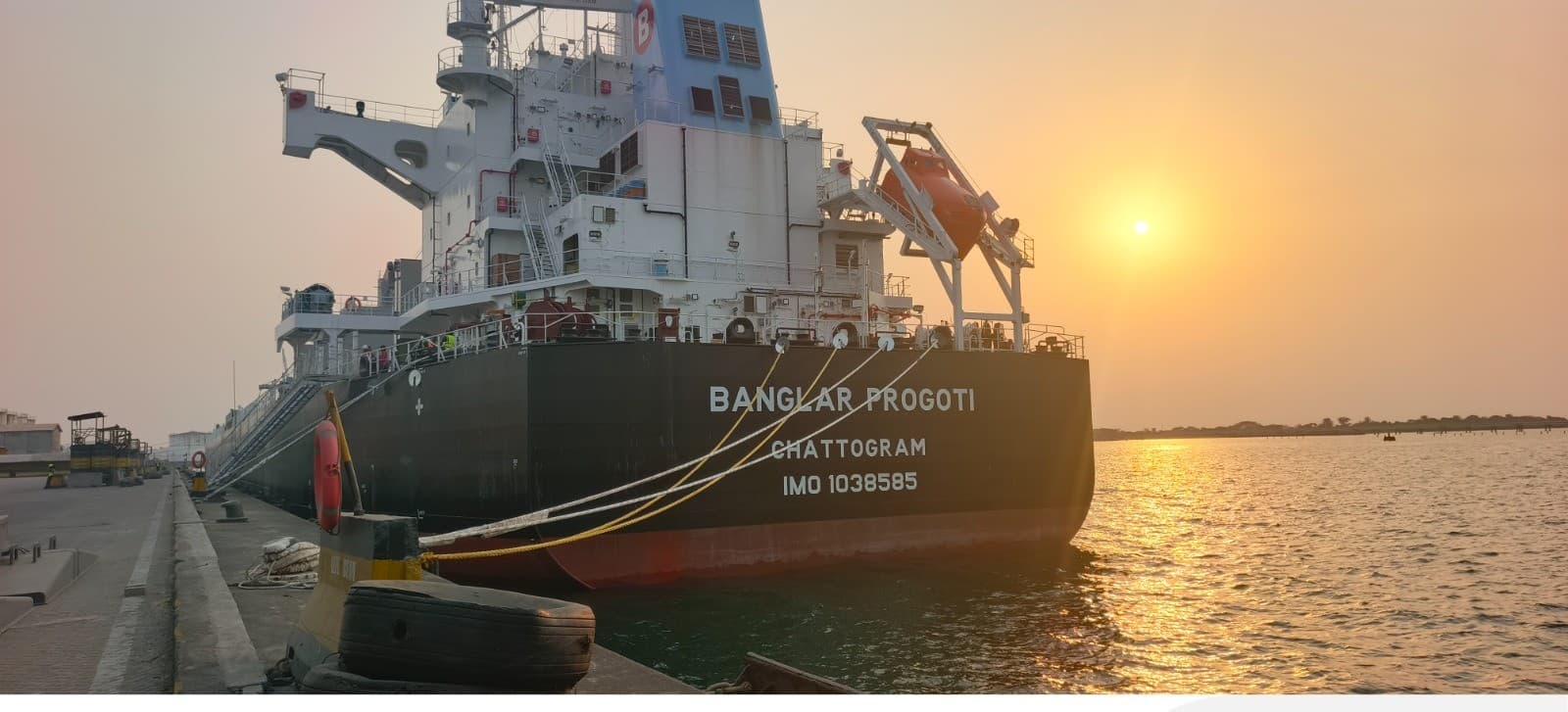 Bulk carrier BANGLAR PROGOTI docked at port at sunset